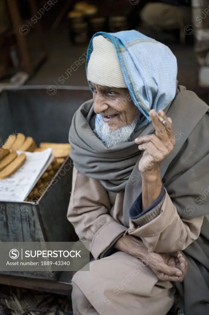 Old Delhi, India; Elderly man smoking