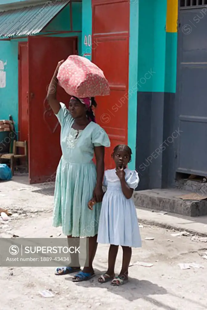 Haiti; Mother and daughter standing in street