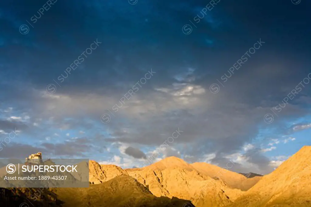 Ladakh, India; Lone building sitting atop rugged mountain range