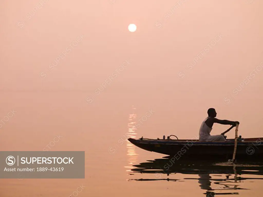 Ganges River,Varanasi,India;Person rowing canoe on the river at sunset