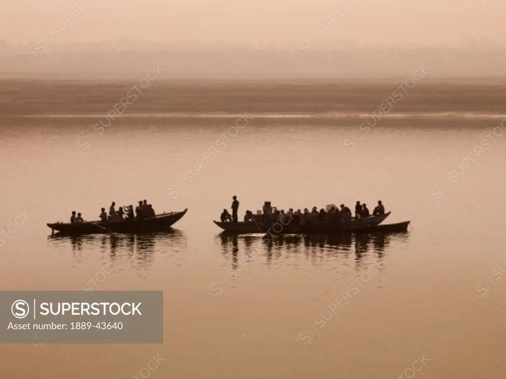 Ganges River,Varanasi,India;Two boats full of people on the river at sunset