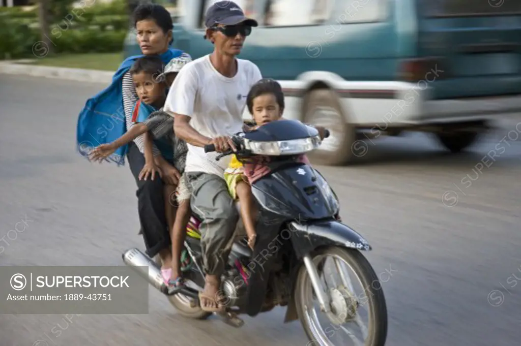 Siem Reap,Cambodia;Family riding on a scooter together without safety helmets