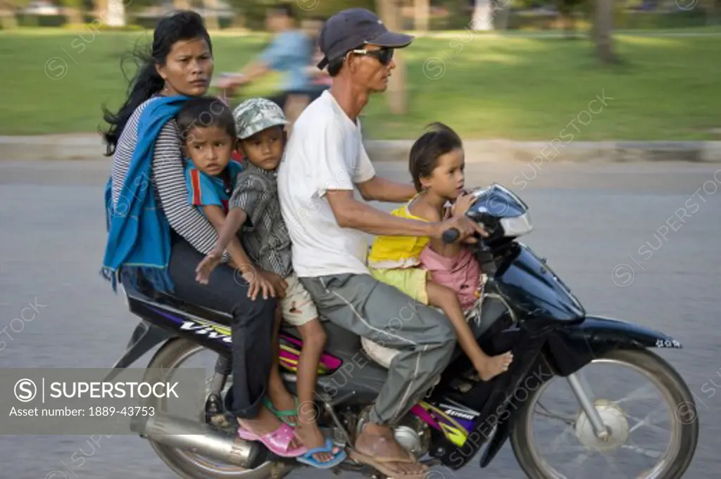 Siem Reap,Cambodia;Family riding on a scooter together without safety helmets