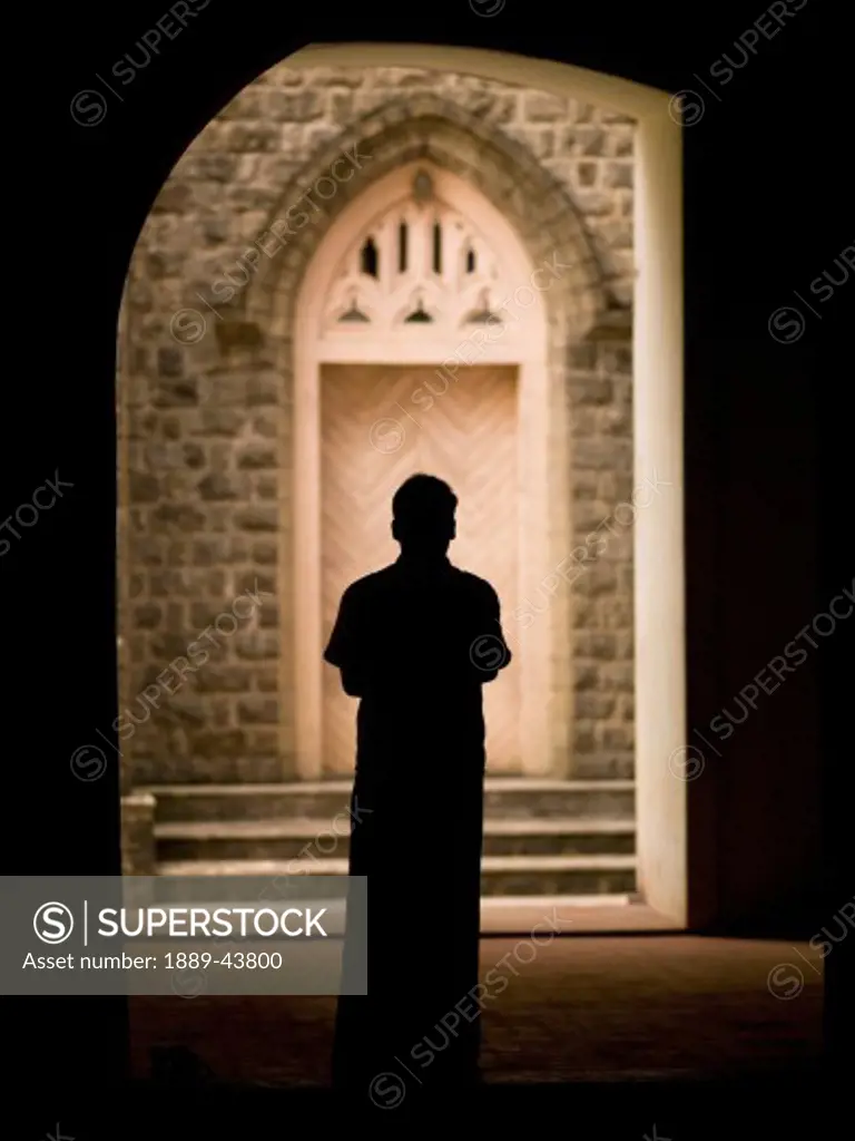 Kerala,India;Silhouetted man standing in doorway of a cathedral