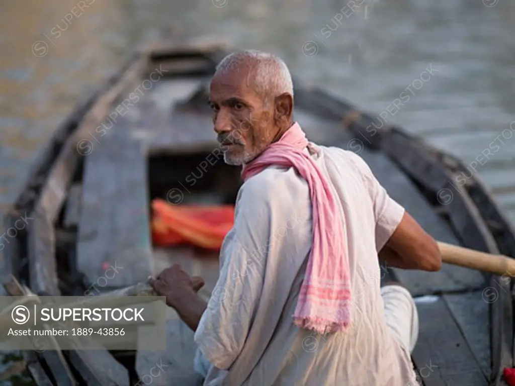 Varanasi,India;Man rowing a boat on the Ganges River