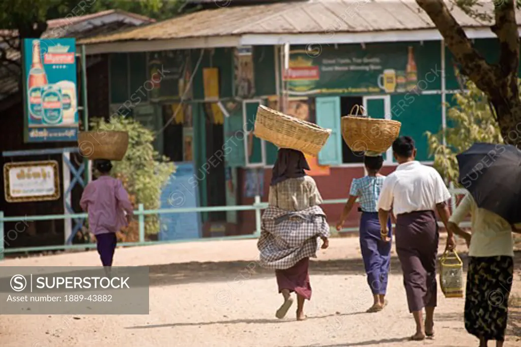 Bagan,Myanmar;Women walking to market with baskets on their heads