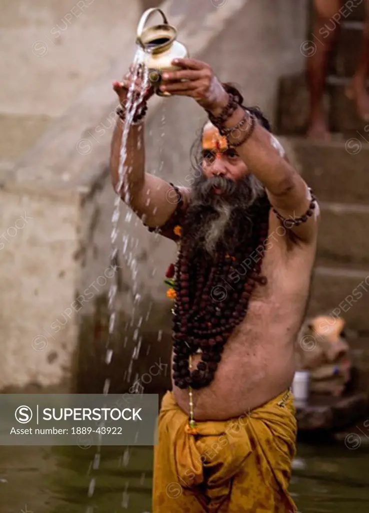 The Ganges River,Varanasi,India;A Sadhu pouring libations into the Ganges