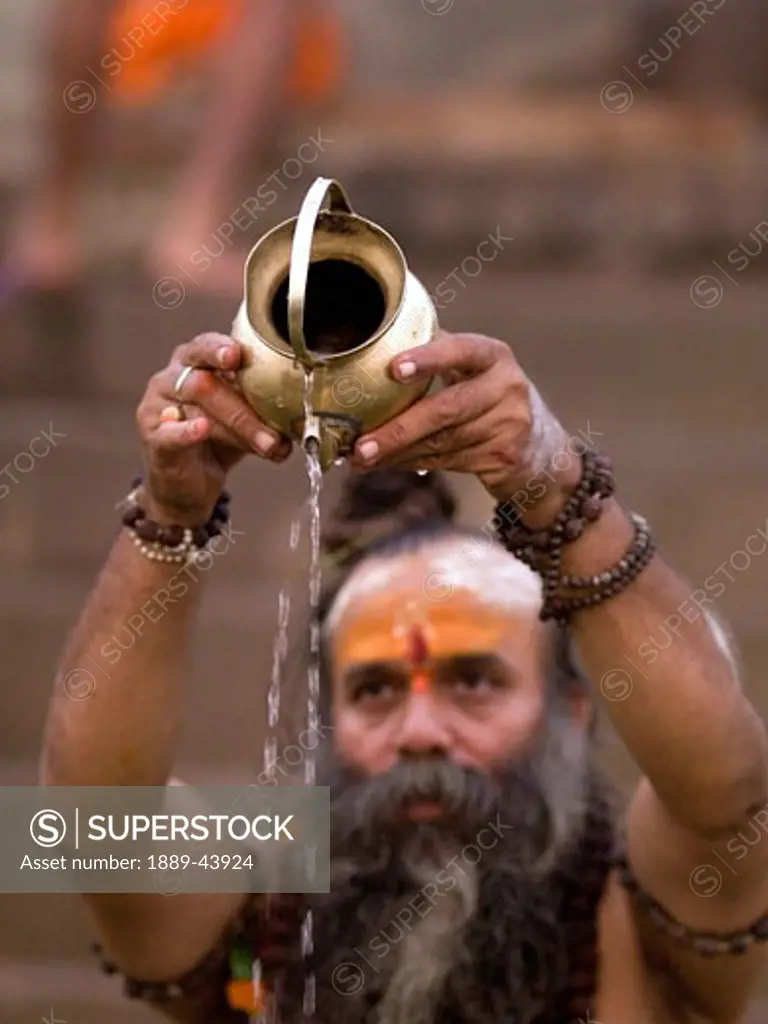 Ganges River,Varanasi,India;A Sadhu pouring libations into the Ganges
