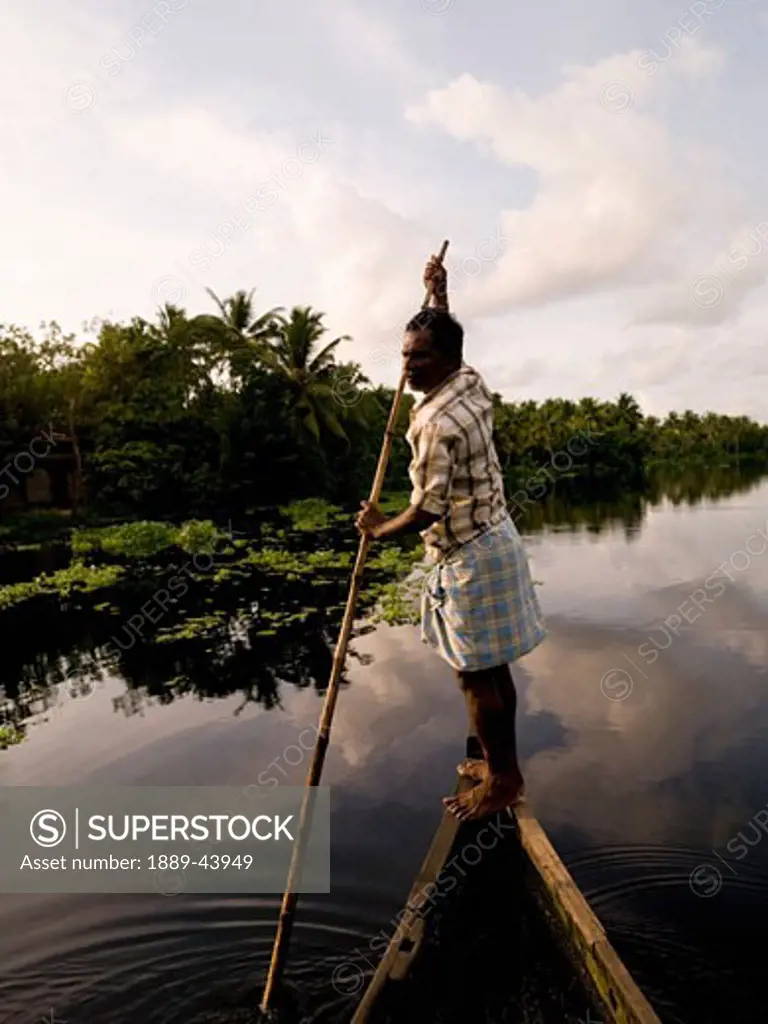 Alleppey,Karala,India;Man punts down Alleppey backwaters