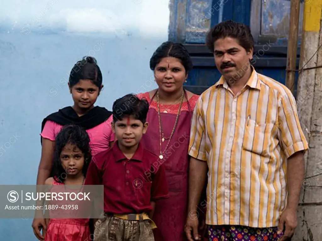 Kochi,Kerala,India;Portrait of well dressed Indian family in front of their home