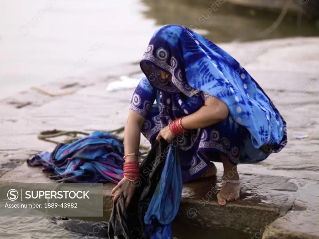 Ganges River,Varanasi,India;Woman washing her clothes in the Ganges
