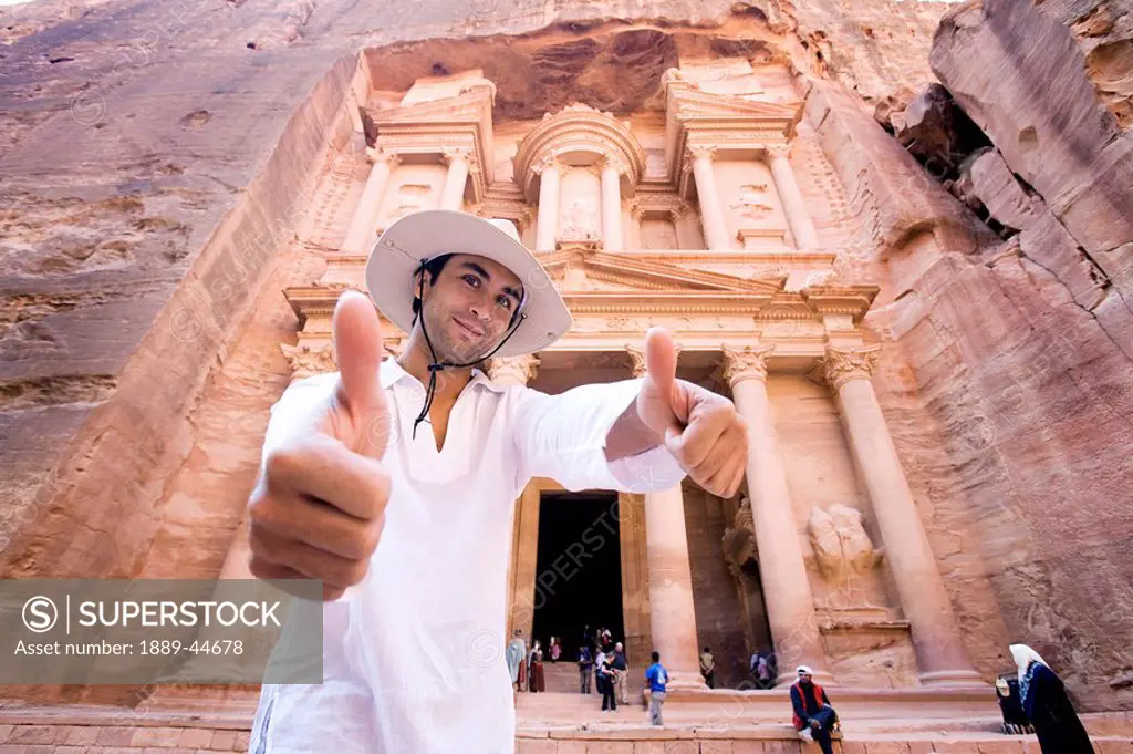 Man giving thumbs up standing by Al Khazneh in Petra