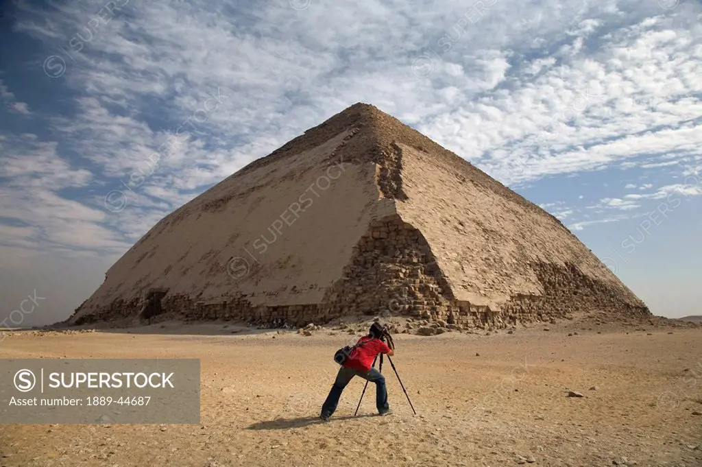 A man taking a picture of a Pyramid