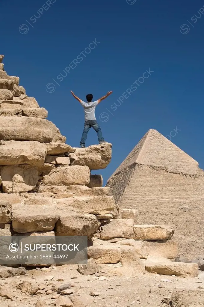 Man standing on part of a Pyramid in the desert