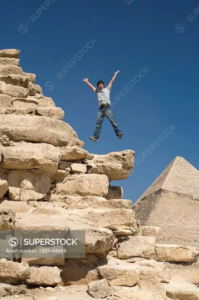 Man jumping on part of a Pyramid in the desert