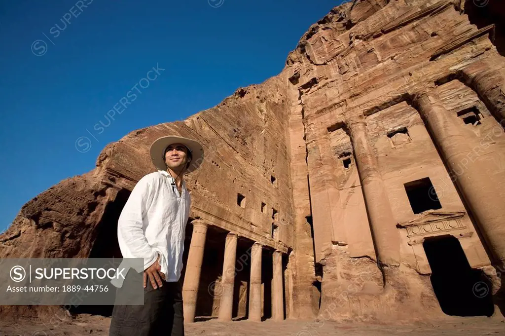 Man standing by royal tomb in Petra