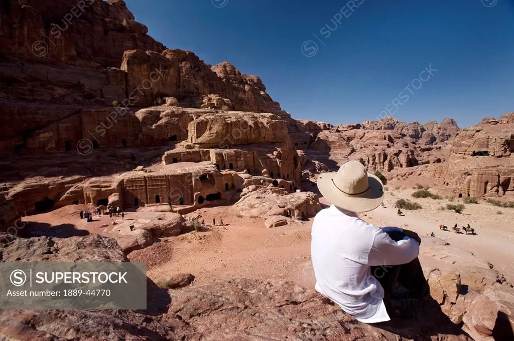 Man sitting near monumental Nabataean tombs