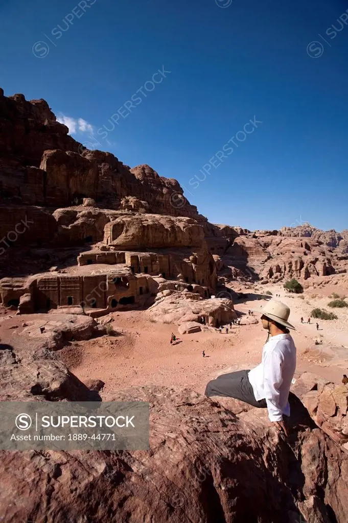 Man sitting near monumental Nabataean tombs
