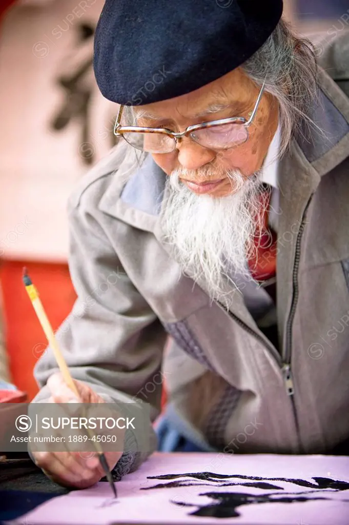 Man writing asian lettering