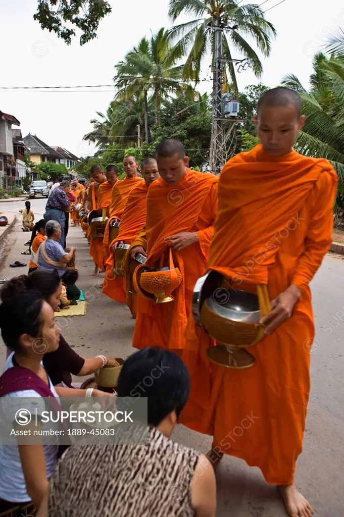 Buddhist monk getting offerings from crowd