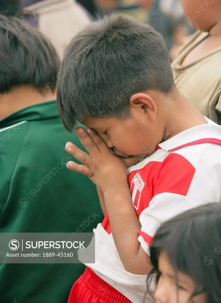 Child praying, Lima, Peru