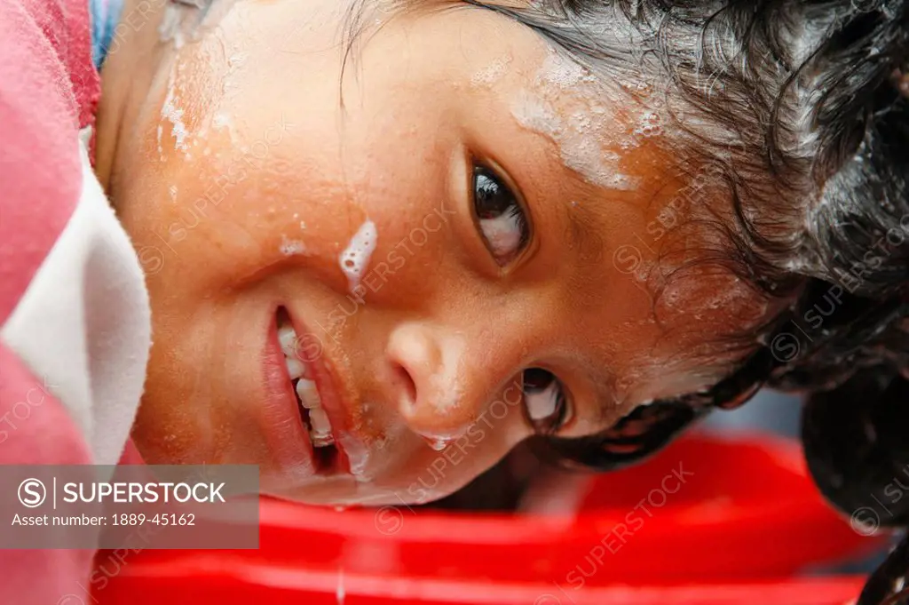 Child washing their face, Lima, Peru