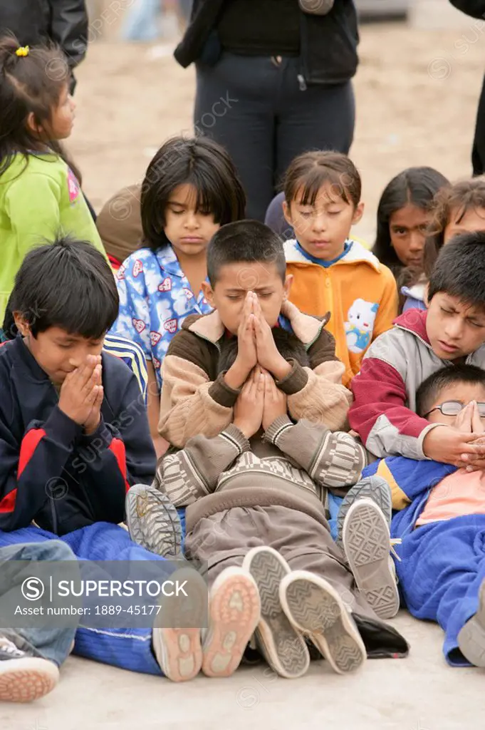 Young children praying, Lima, Peru