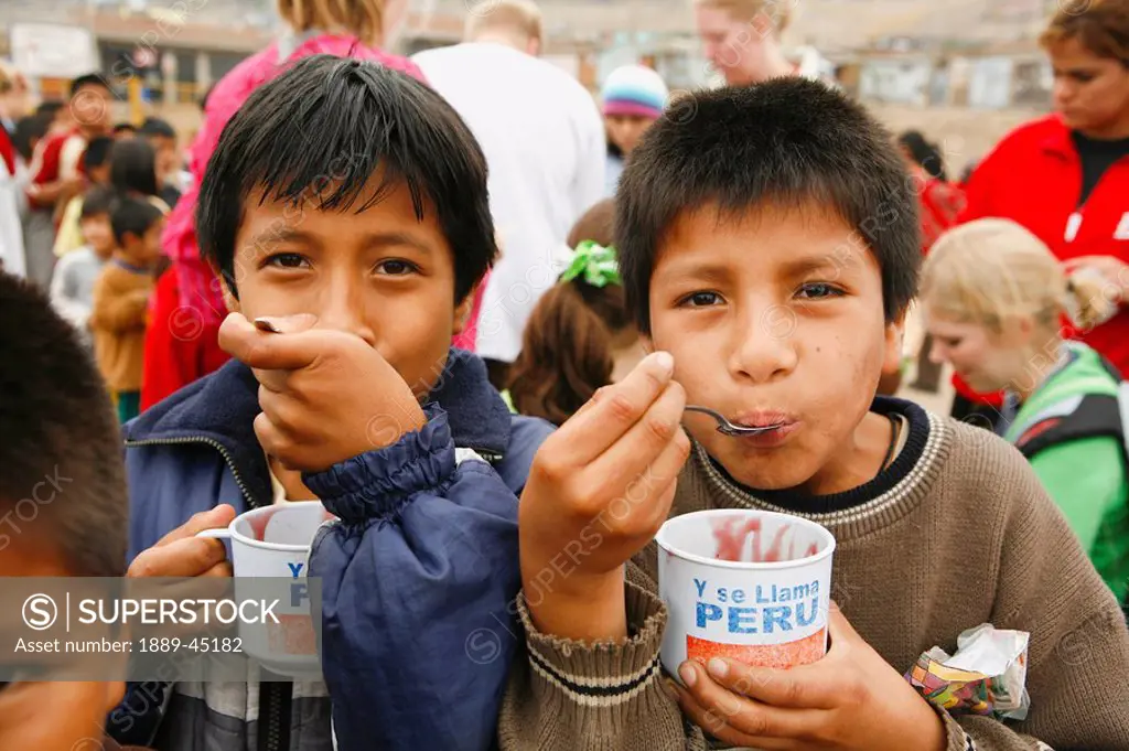 Young boys eating, Lima, Peru