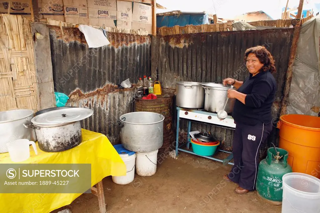 Woman cooking in yard, Lima, Peru