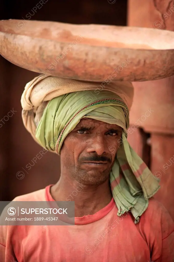 Man carrying bowl on head