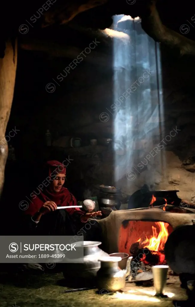 Woman cooking by the fire