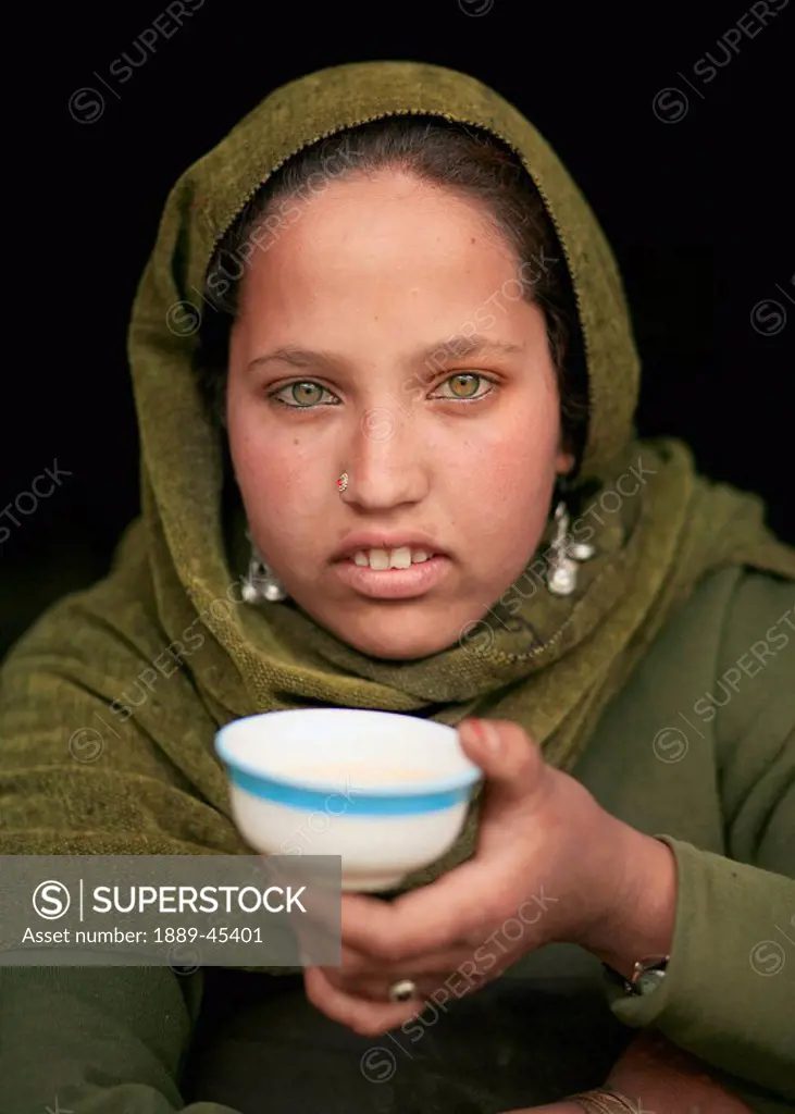 A Gujjar girl with a cup of salt tea. Lidderwat, Kashmir, India