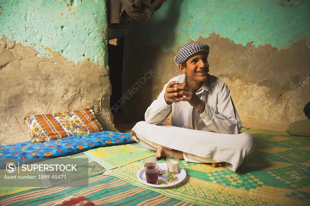 Berber man having tea inside his colourful home