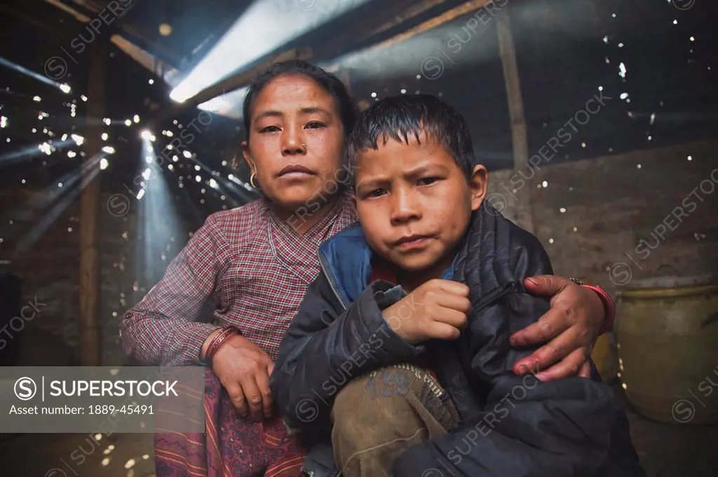 Mother and son inside smoky cook shack, Pokhara, Nepal