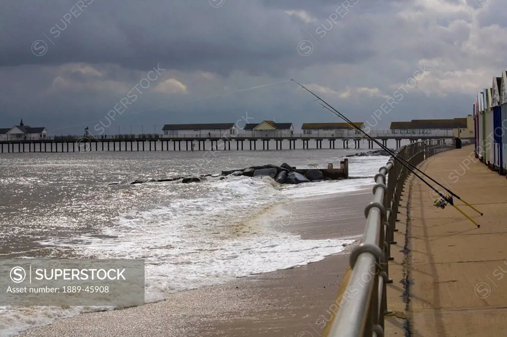 suffolk, england, fishing rods hanging off the pier on the coast of the north sea
