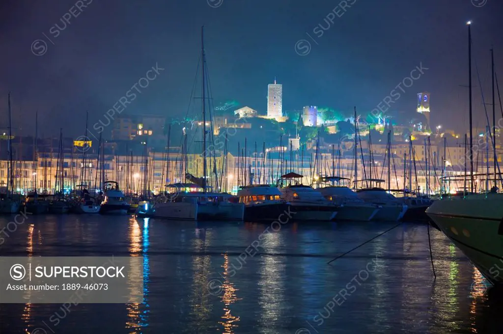 cannes, provence, france, buildings illuminated on shore and the harbor at night
