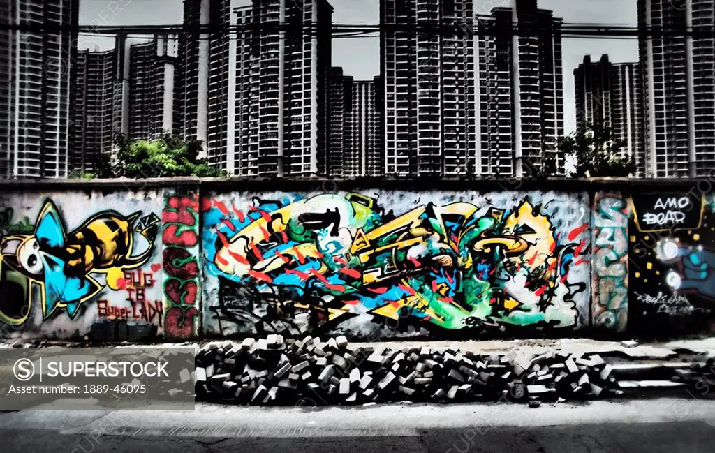 a wall of graffiti below highrises
