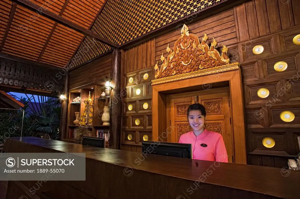 Thailand, A Female Worker At The Desk Of An Outdoor Hotel Lobby