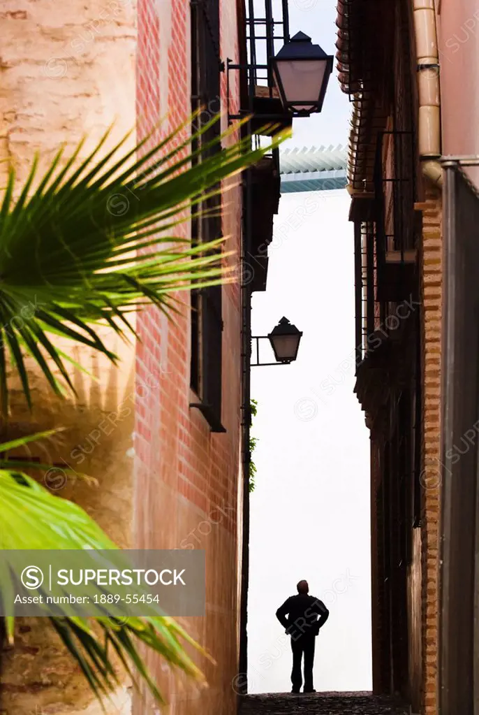 malaga, andalusia, spain, silhouetted figure of a man in a narrow street in costa del sol
