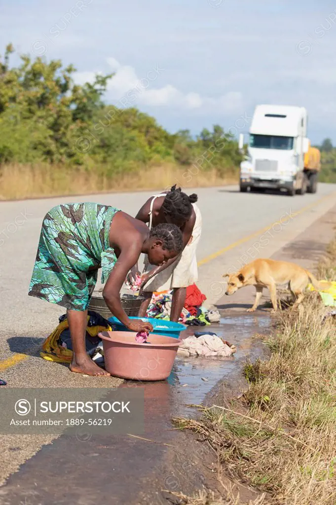 women doing laundry on the side of the road, manica, mozambique, africa