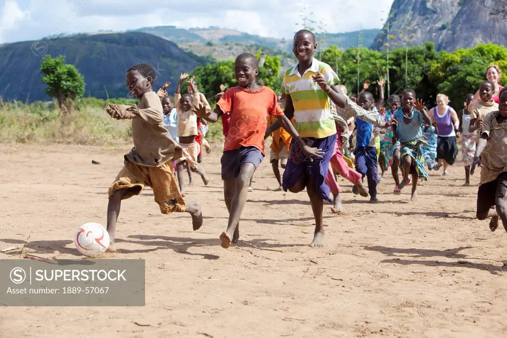 A Group Of Children Running After A Ball, Manica, Mozambique, Africa