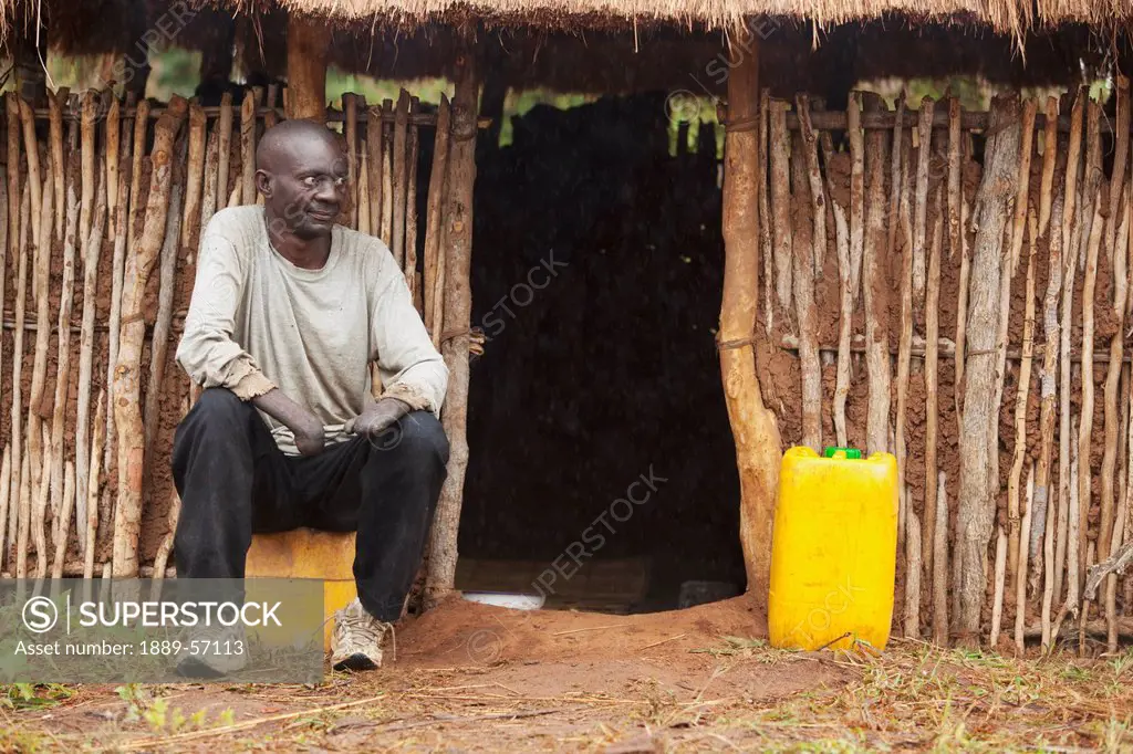 A Man With Leprosy Sits Outside A Building, Manica, Mozambique, Africa