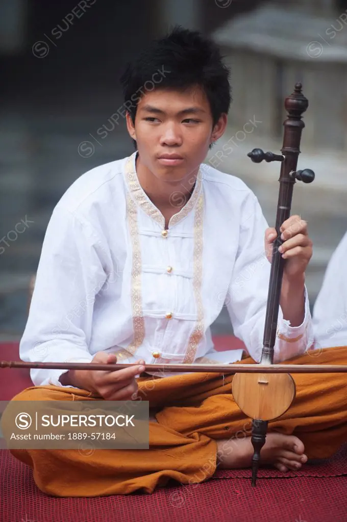 A Thai Boy Performs With A Thai Traditional Instrument, Chiang Mai, Thailand