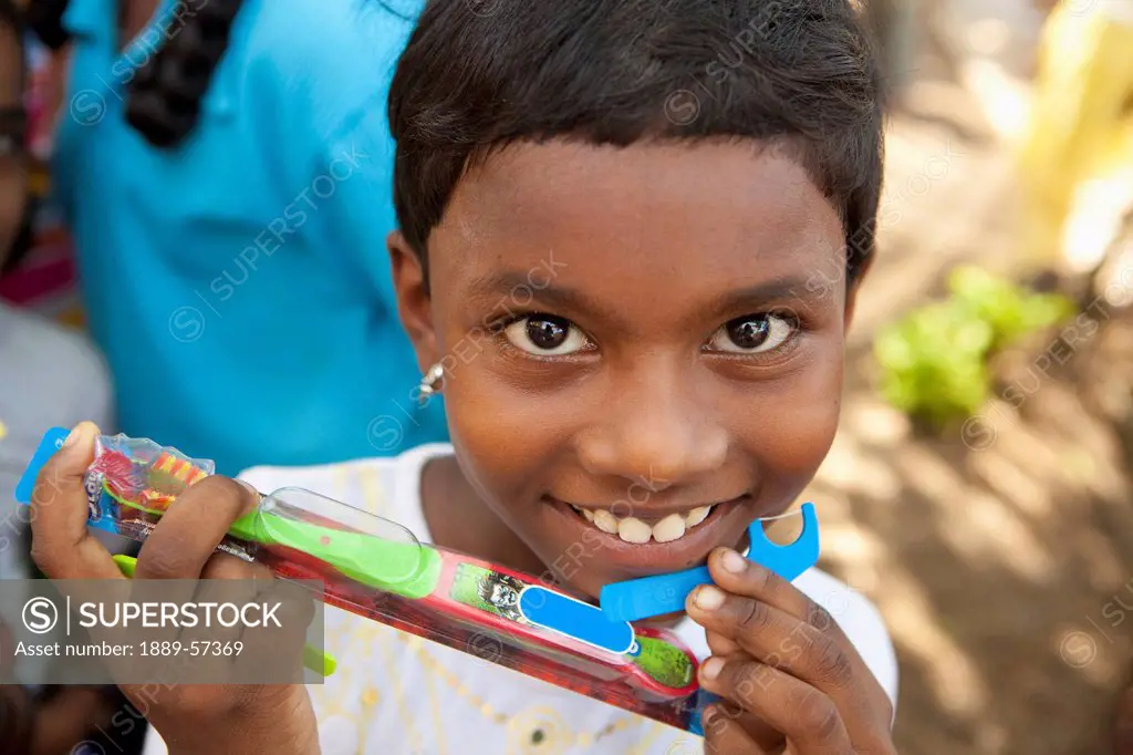 A Child Holding A New Toothbrush And Flosser, Sathyamangalum, Tamil Nadu, India