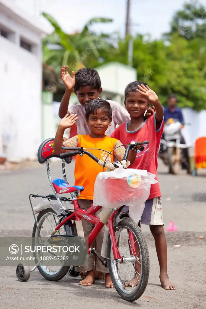 Three Children Waving With A Bicycle In The Street, Sathyamangalam, Tamil Nadu, India