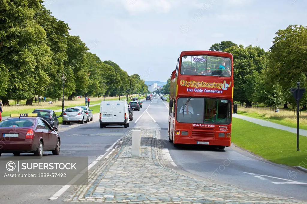 a double_decker bus travelling on the road around phoenix park, dublin, ireland
