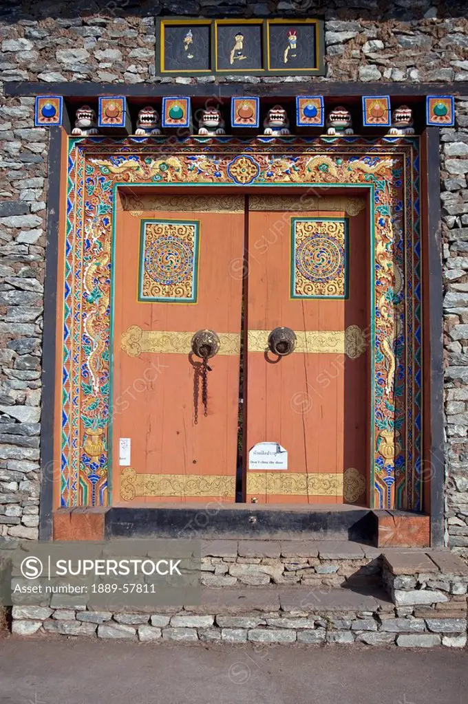 Painting on doorway in rock wall, Bhutan