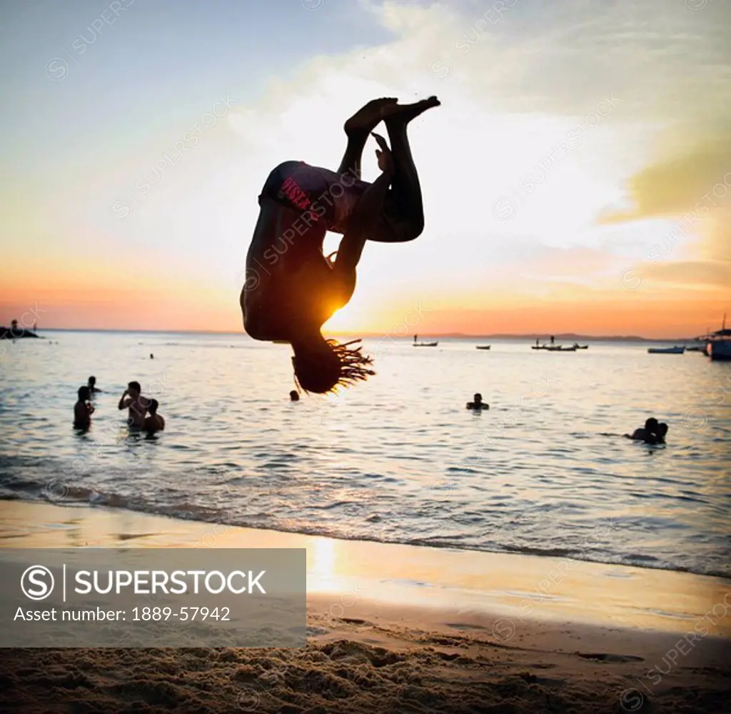 Person doing somersault on beach, Salvador, Bahia, Brazil