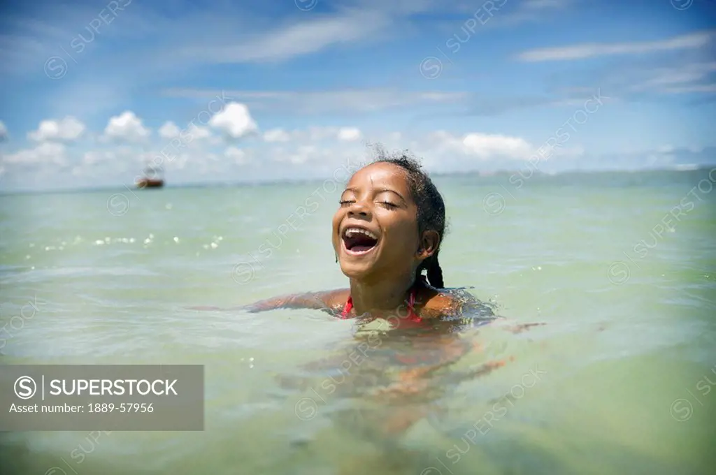 Young girl swimming in ocean, Brazil