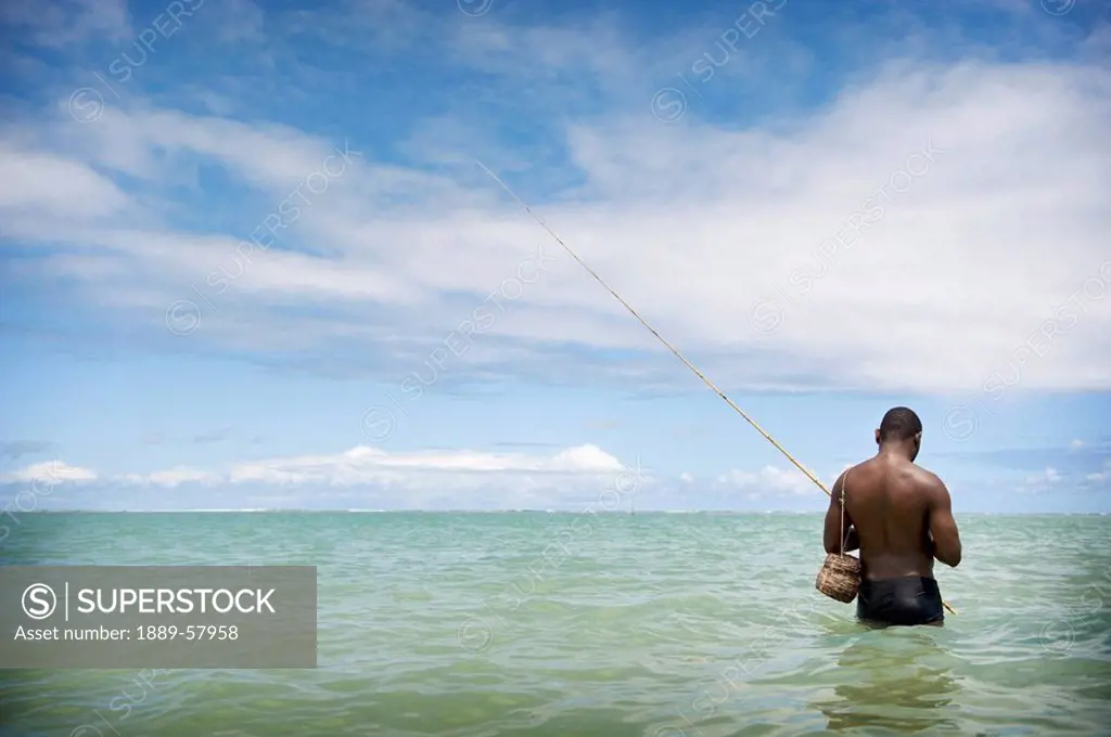 Fisherman wading into the ocean, Brazil
